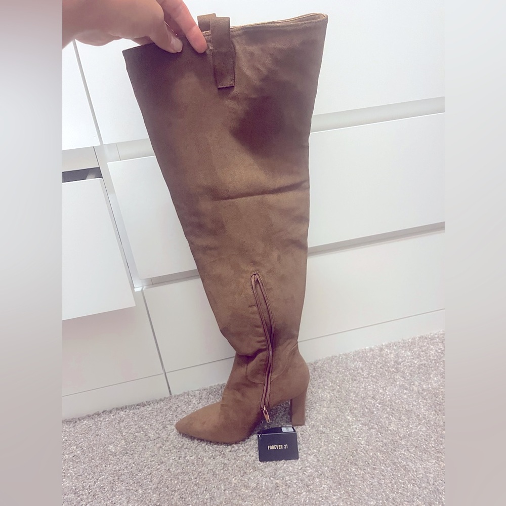 Brown thigh high suede boots.